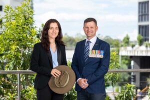 Business woman and business man smiling confidently and proudly wearing their service medals.